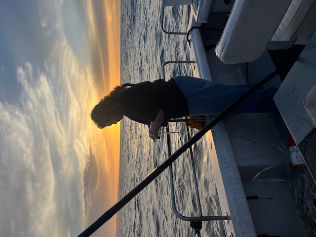 Silhouette of woman fishing at sunset on Monterey Bay