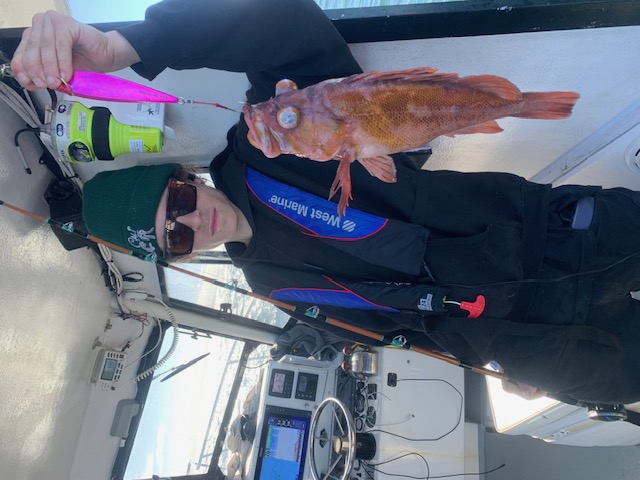Young angler holding rockfish catch aboard the Pescador
