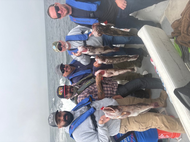 Group of five veterans with lingcod haul on fishing trip