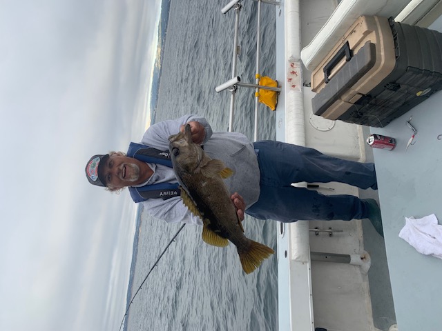Veteran proudly holding bass catch on Monterey Bay