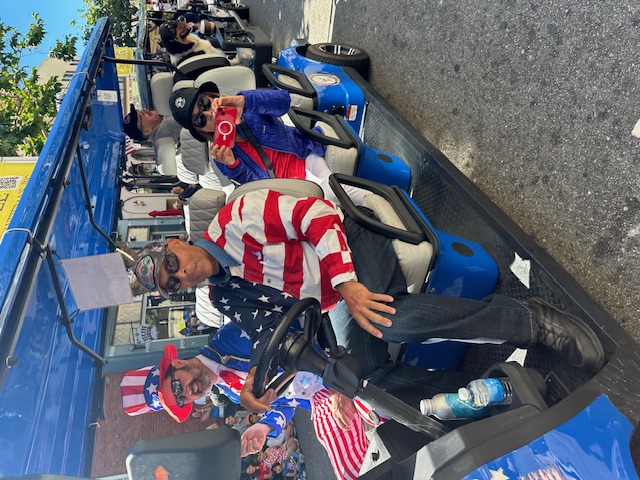 Patriotic volunteer in American flag shirt driving MBV shuttle