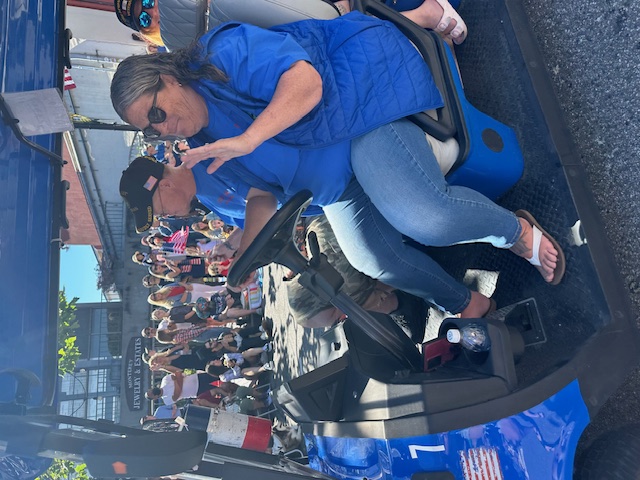 Volunteer driving MBV shuttle through parade crowd