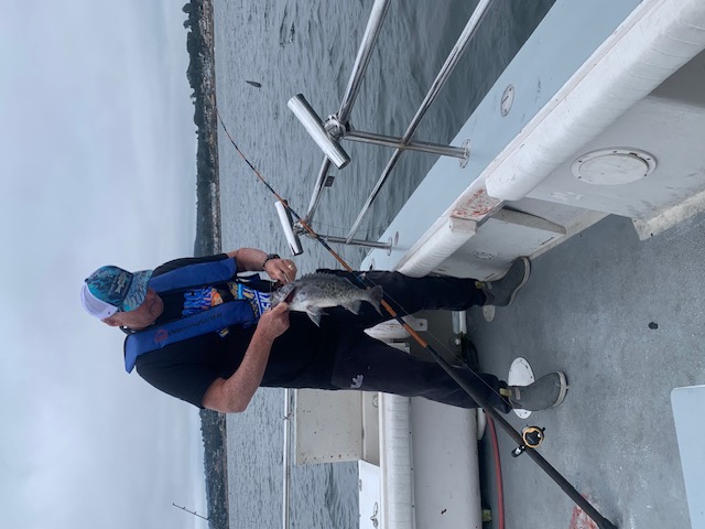 Veteran unhooking fish on the deck of the Pescador