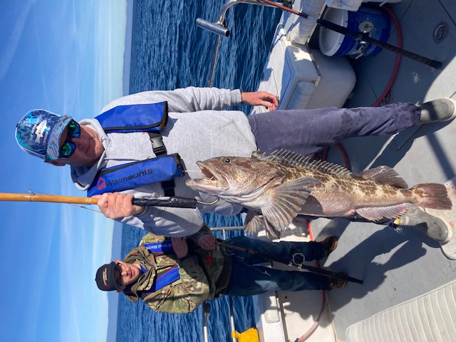 Veteran holding large lingcod catch on fishing trip