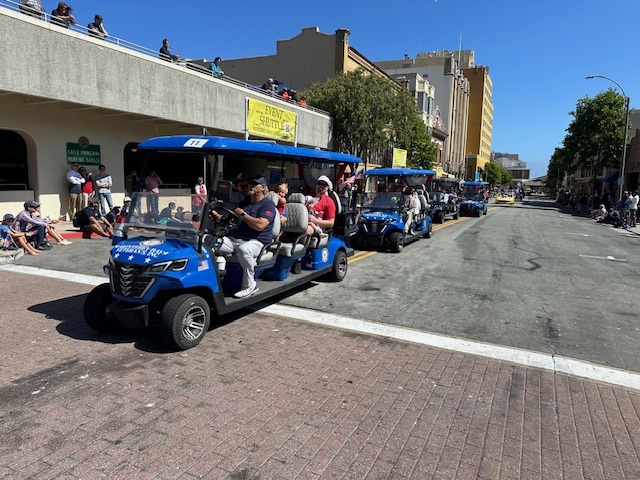 Fleet of blue MBV ADA shuttles in downtown parade